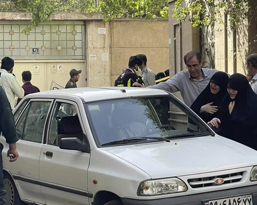 In this photo provided by Islamic Republic News Agency, IRNA, family members of Col.  Hassan Sayyad Khodaei weep over his body at his car after being shot by two assailants in Tehran, Iran, Sunday, May 22, 2022. Hassan Sayyad Khodaei, a senior member of Iran's powerful Revolutionary Guard, was killed outside his home in Tehran on Sunday by unidentified gunmen on a motorbike, state TV reported.