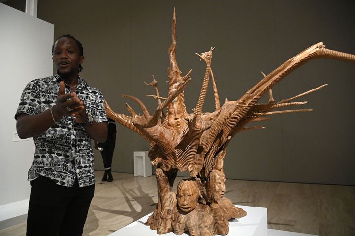 The Beninese sculptor Degnon Toihen in front of one of his works exhibited at&nbsp;"Art from Benin yesterday and today, from restitution to revelation", Saturday February 19, 2022 in Cotonou (Benin).  (PIUS UTOMI EKPEI / AFP)