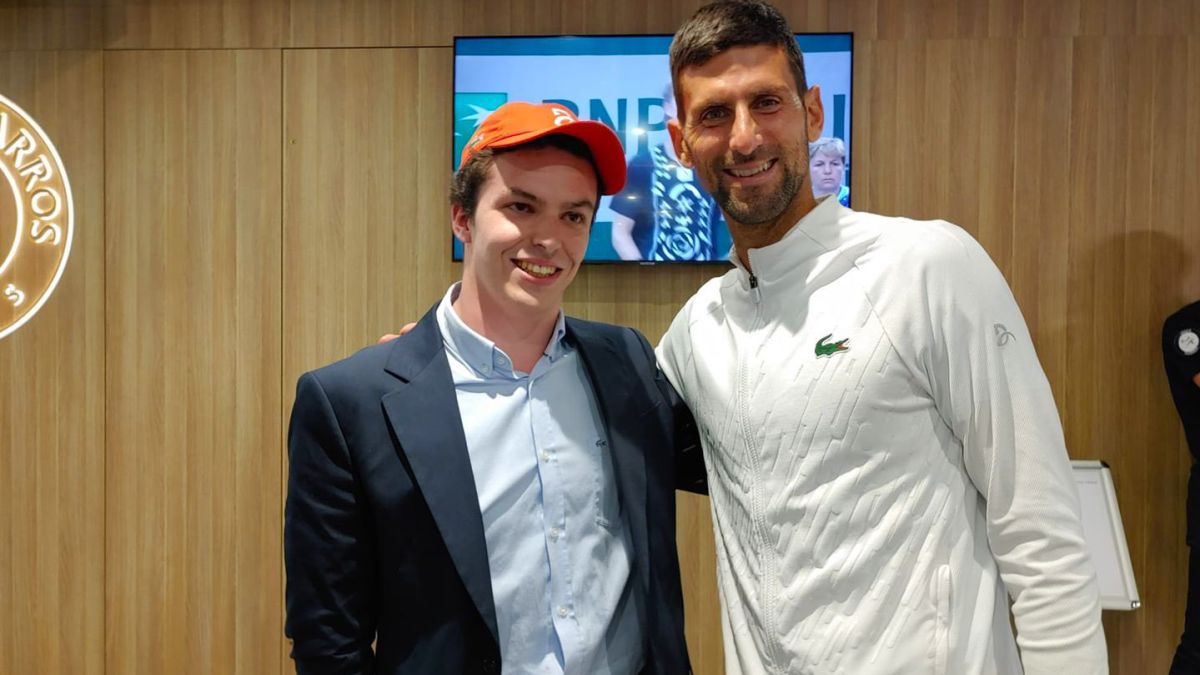 El tenista serbio Novak Djokovic posa con el aficionado francés Arthur Delaye, que pese a sufrir una parálisis cerebral no ha dejado de disfrutar de su pasión sobre una pista de tenis.