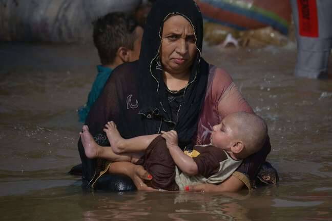A woman refreshes her son in a canal in Pakistan on May 8, 2022.