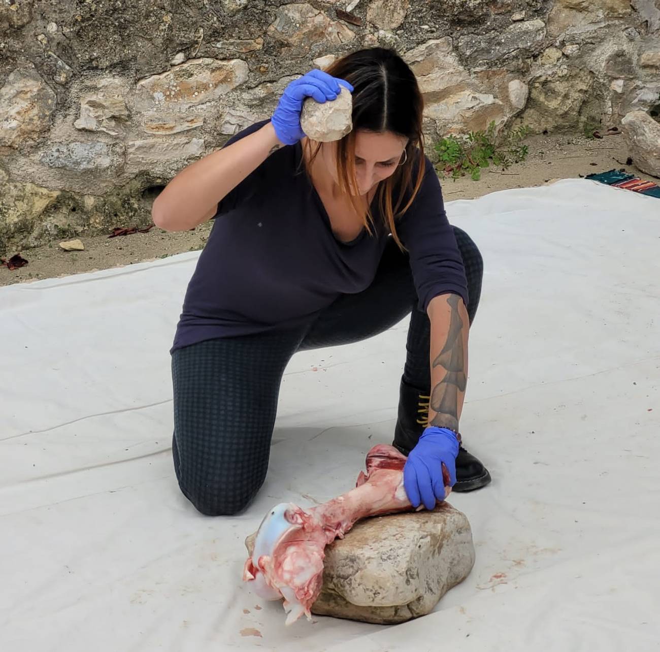 Stefania Titton (URV) butchering an experimental spheroid in limestone in the region around the Acheulian site of Ubeidiya (Israel).  /g.  sharon