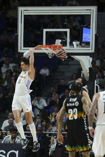 Mario Hezonja, a Madrid forward, dunks with his back against Michale Kyser, from Bilbao Basket.