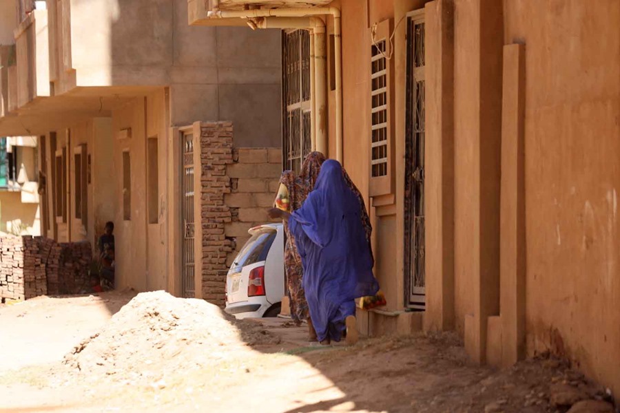 A woman walks down a street in Khartoum, Sudan.