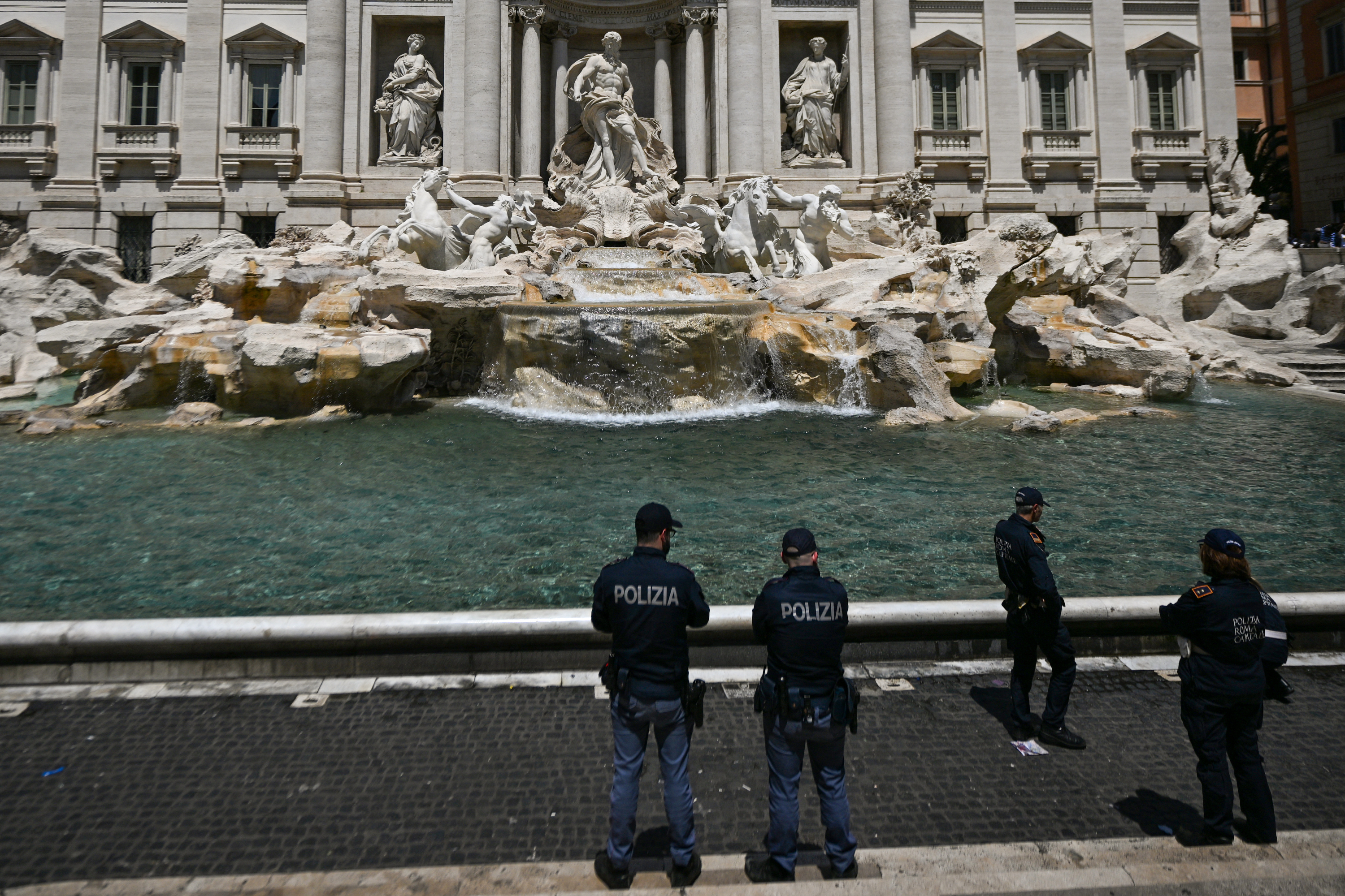 Police stand guard May 21, 2023 at the Fontana di Trevi fountain in central Rome after Last Generation (Ultima Generazione) environmental activists spill black liquid