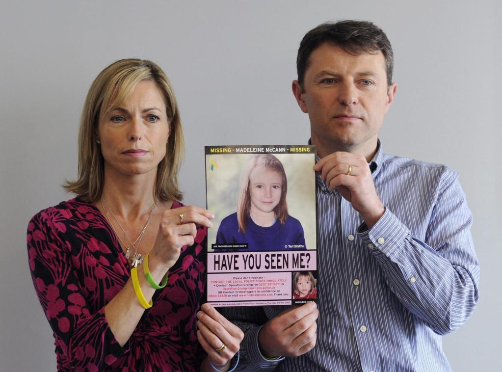 FILE - In this May 2, 2012 file photo, Kate McCann and her husband, Gerry McCann, hold a sign with a picture of their missing 2007 daughter, Madeleine McCann.