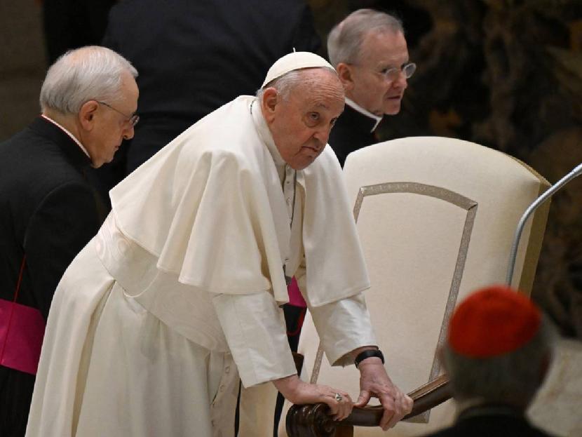 Pope Francis sits. 