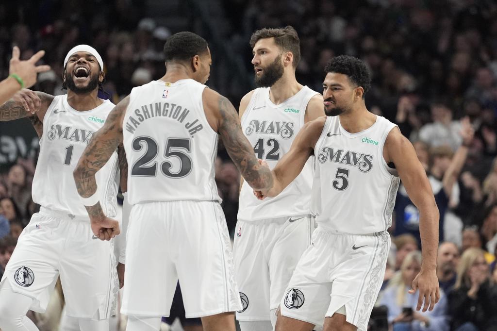 Dallas Mavericks guard Quentin Grimes (5) celebrates with teammates forward PJ Washington (25), guard Jaden Hardy (1) and forward Maxi Kleber (42) during the second half of an NBA basketball game against the Los Angeles Lakers, Tuesday, Jan. 7, 2025, in Dallas. (AP Photo/LM Otero)