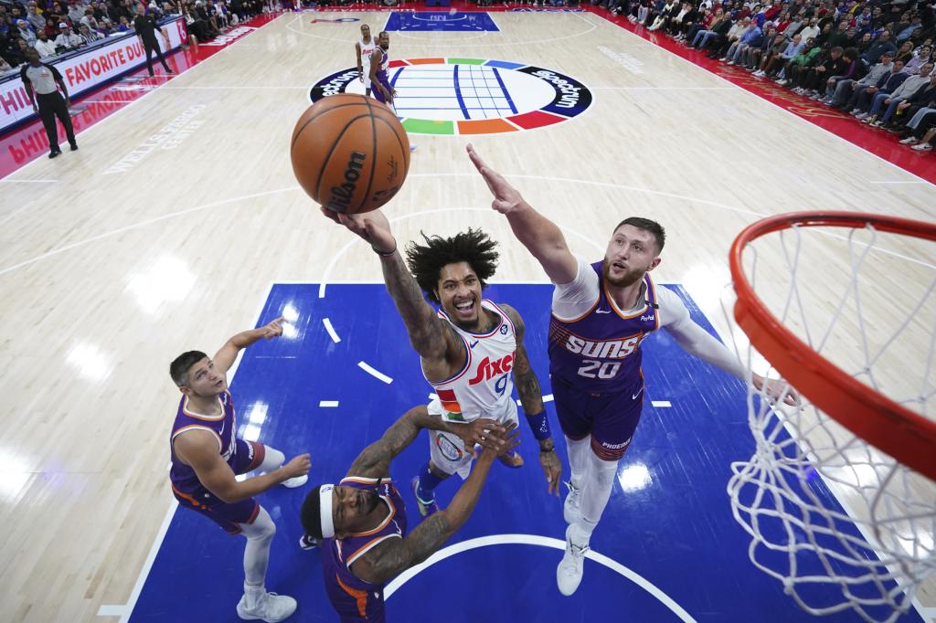 Philadelphia 76ers' Kelly Oubre Jr., center, goes up for a shot between Phoenix Suns' Jusuf Nurkic, right, and Bradley Beal during the second half of an NBA basketball game, Monday, Monday, Jan. 6, 2025, in Philadelphia. (AP Photo/Matt Slocum)