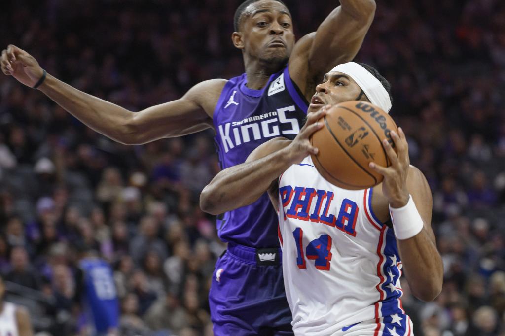 Philadelphia 76ers guard Ricky Council IV (14) drives to the basket past Sacramento Kings guard De'Aaron Fox during the first half of an NBA basketball game in Sacramento, Calif., Wednesday, Jan. 1, 2025. (AP Photo/Randall Benton )