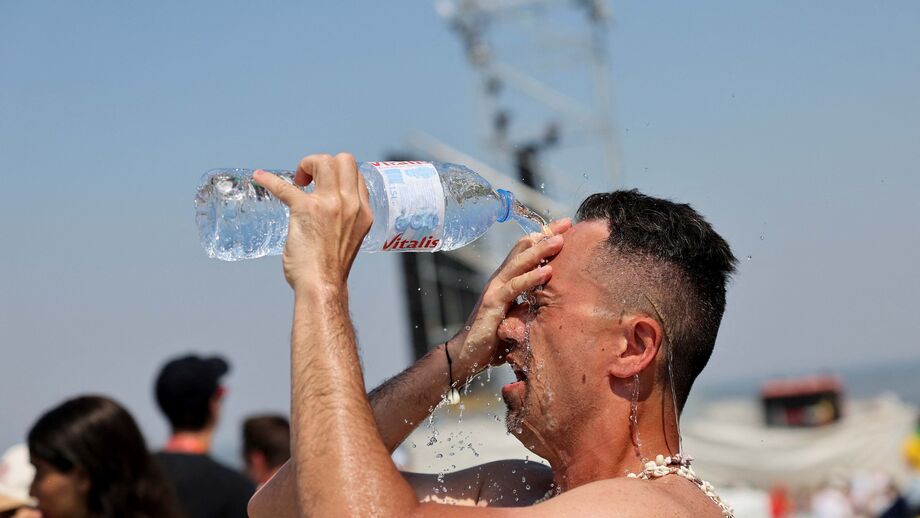 Football players on a field under bright sunlight, indicating hot conditions.