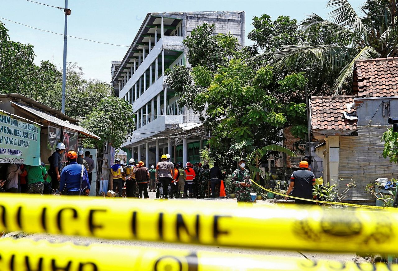Heavy machinery helps clear debris after the school collapse