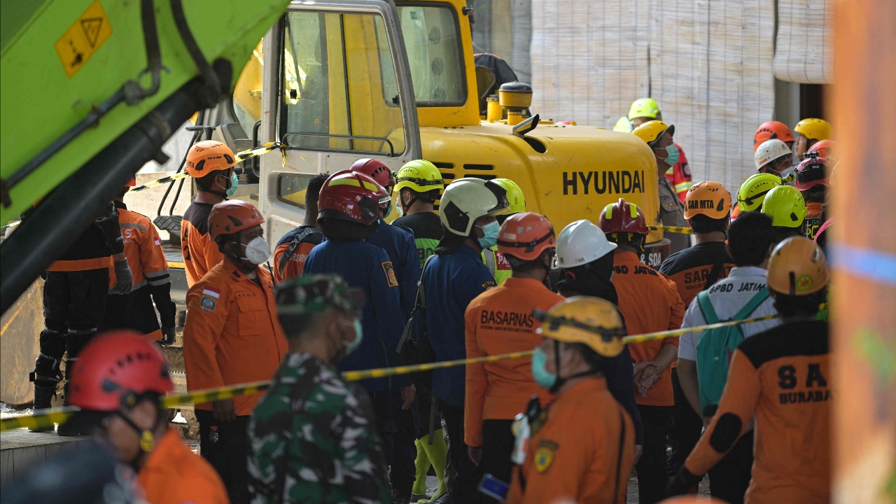 Rescue workers sift through the wreckage of a collapsed school building